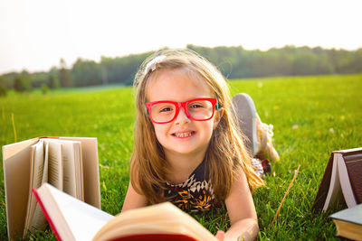 Portrait of young woman using laptop while sitting on field