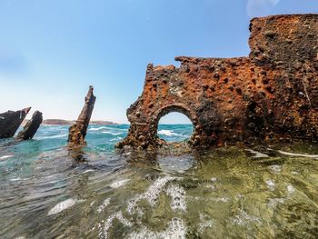 Old ruin by sea against clear blue sky
