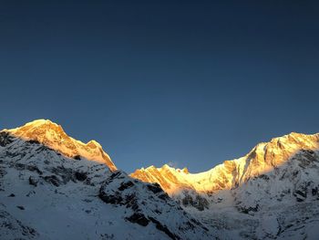 Scenic view of snowcapped mountains against clear sky