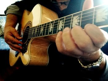 Close-up of man playing guitar