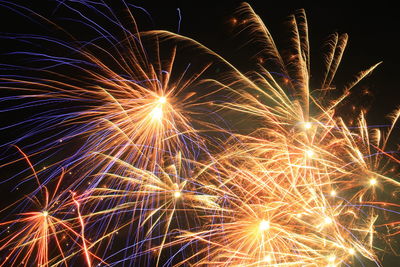 Low angle view of firework display at night