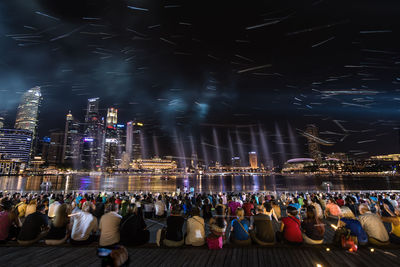 People by waterfront at night