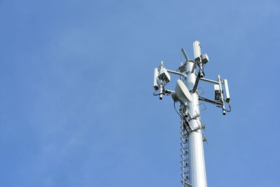 Low angle view of communications tower against clear blue sky