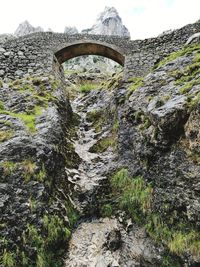 Low angle view of bridge over mountain against sky