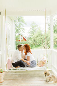 Couple kissing on swing in terrace