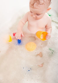 High angle view of girl playing with toys in bathtub