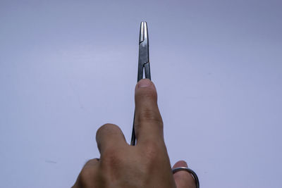 Midsection of person holding umbrella against clear blue sky