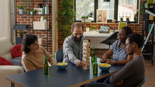 Side view of friends using mobile phone at restaurant