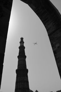 Low angle view of airplane flying in city against clear sky