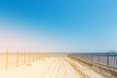 Scenic view of beach against clear blue sky