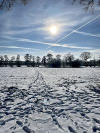 Snow covered field against sky