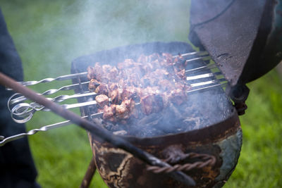 Midsection of man preparing food on barbecue grill