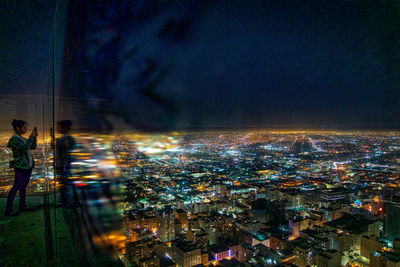 Illuminated cityscape against sky at night