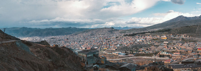 Aerial view of townscape against cloudy sky