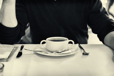 Low section of woman sitting on table at cafe