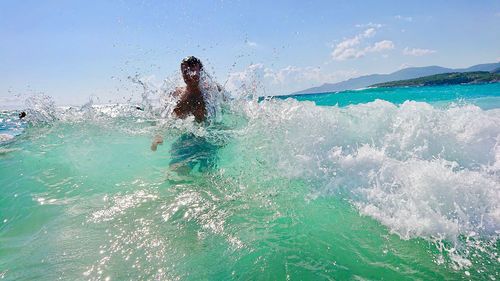 Woman swimming in sea against sky