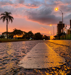 Surface level of road against sky at sunset