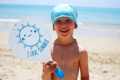 Portrait of smiling boy standing at beach