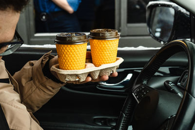 Midsection of man holding food in car