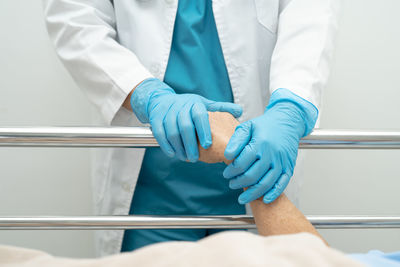 Midsection of doctor examining patient in hospital