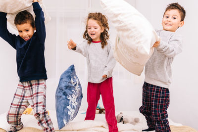 Friends playing on bed at home