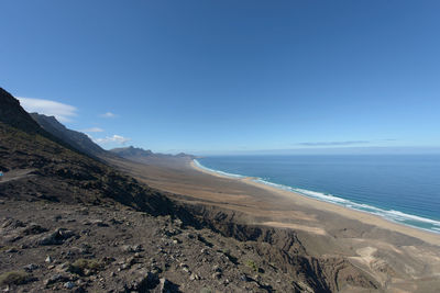 Scenic view of beach against blue sky