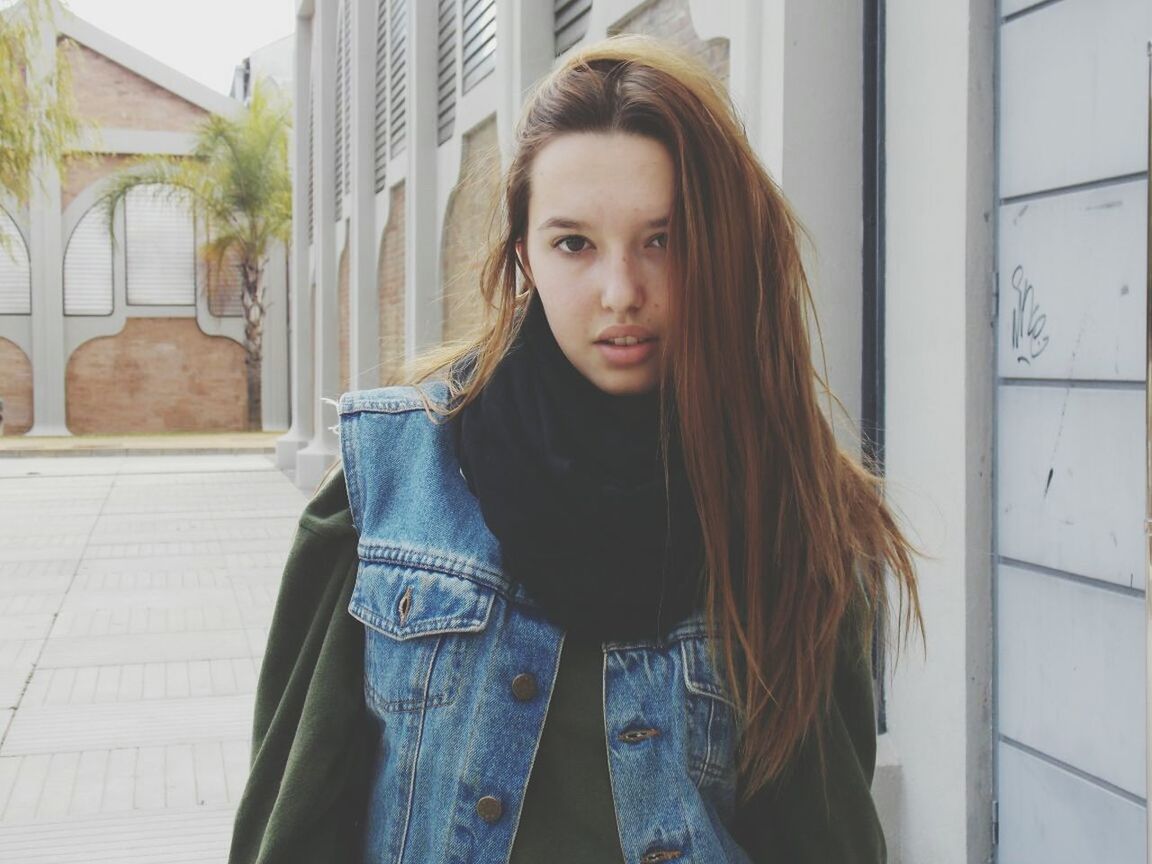 person, portrait, looking at camera, long hair, young adult, young women, casual clothing, front view, lifestyles, smiling, leisure activity, standing, waist up, brown hair, blond hair, built structure, architecture