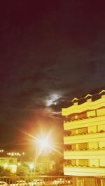 Low angle view of illuminated buildings against sky at sunset