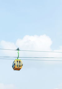 Low angle view of overhead cable car against sky