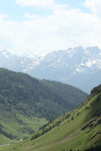 Scenic view of green landscape and mountains against sky