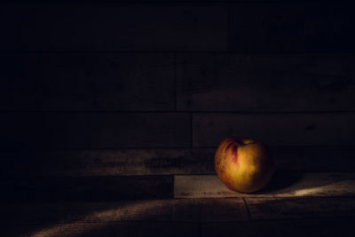 Close-up of apple on table against wall