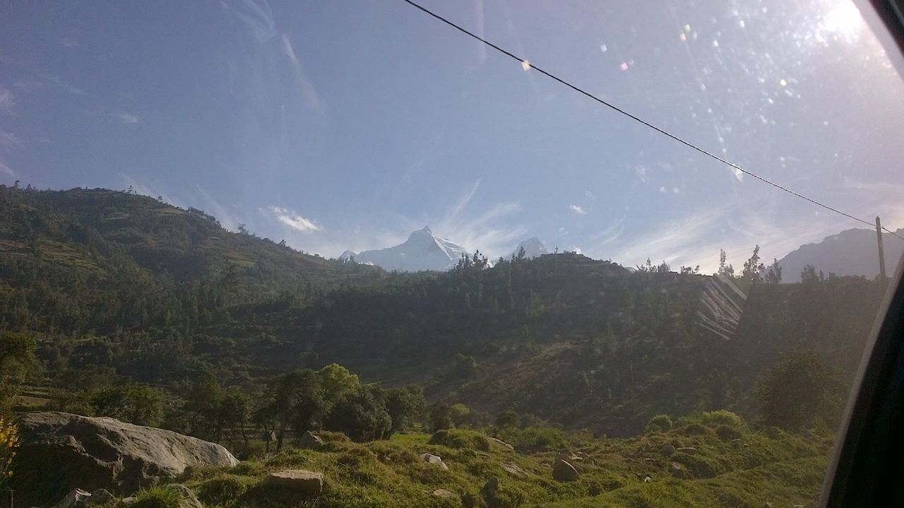 COUNTRYSIDE LANDSCAPE AGAINST MOUNTAIN RANGE