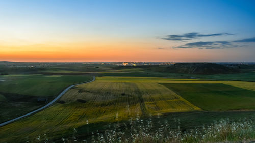 Scenic view of field against sky during sunset