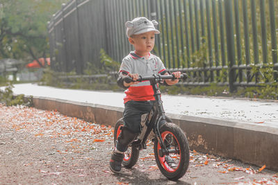 Portrait of cute toddler boy riding a push bike