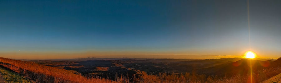 Scenic view of field against clear sky during sunset