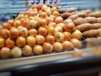 Large oninos arranged on a shelve on a grocery shop