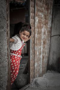 Young woman standing against wall