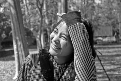 Close-up of smiling young woman hiking in forest