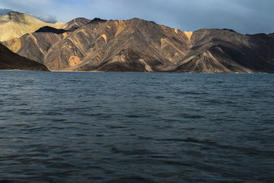 Scenic view of sea and mountains against sky