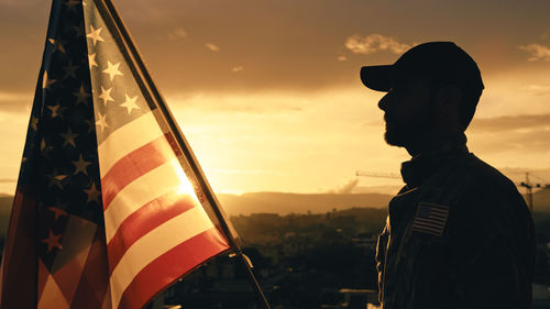 Rear view of man with flag against sky