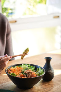 Midsection of person having food on table