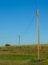 View of field against clear blue sky