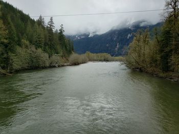 Scenic view of river amidst mountains against sky