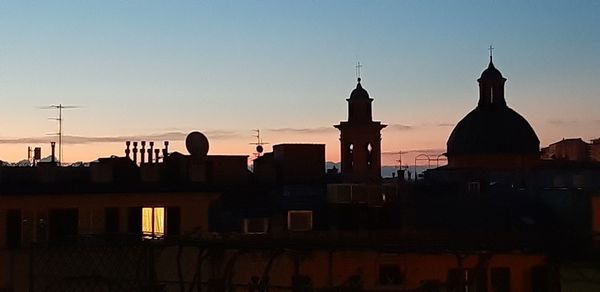 Silhouette of buildings against sky during sunset
