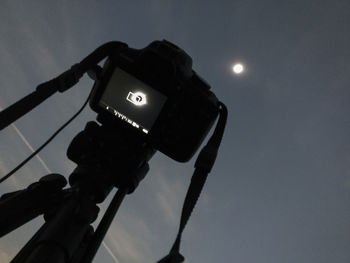 Low angle view of illuminated camera against sky