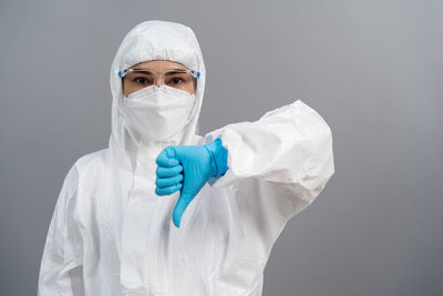 Portrait of female doctor wearing surgical mask against white background