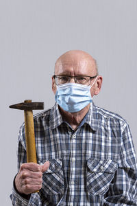 Portrait of man holding umbrella against white background