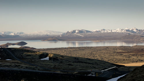 Scenic view of lake by snowcapped mountains against sky