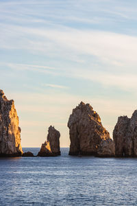 Rock formations in sea against sky