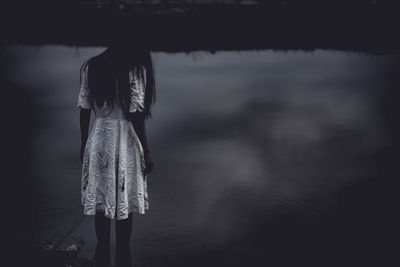 Rear view of woman standing on sea shore